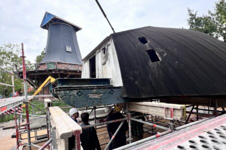Abgesetzte Mühlenhaube auf dem Traggerüst, im Hintergrund der Turm der Kopperhörner Mühle ohne Haube